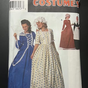 Könnte beinhalten: Eine Simplicity Costumes Schnittmusterhülle, Nummer 713, mit Abbildungen von Kleidern im historischen Stil. Die Verpackung zeigt ein blaues Kleid mit weißer Spitzenborte, ein gelbes Kleid mit Blumenmuster und ein braunes Kleid.
