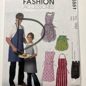 May include: A McCall's Fashion Accessories sewing pattern envelope M5551 in size OSZ. The front displays illustrations of various apron styles, including a blue apron, a floral apron, a green plaid half-apron, a pink floral apron, and a red striped apron.