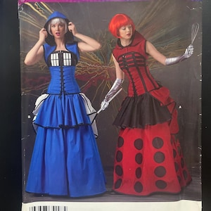 Może przedstawiać: Koperta z wykrojem krawieckim Simplicity Costumes S0232 przedstawiająca dwa wzory sukien z kapturem. Jedna sukienka jest niebieska z białym gorsetem w kratkę, a druga czerwona z czarnymi okrągłymi akcentami. Opakowanie zawiera informacje o rozmiarach.