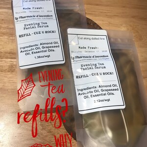 Puede incluir: Dos bolsas de pl&aacute;stico transparentes con etiquetas que dicen "Evening Tea Facial Serum" y "REFILL - CUZ U ROCK!" Las bolsas contienen un l&iacute;quido amarillo. El texto "Evening Tea refills? WHY yes!" est&aacute; escrito en rojo en la parte delantera de las bolsas.