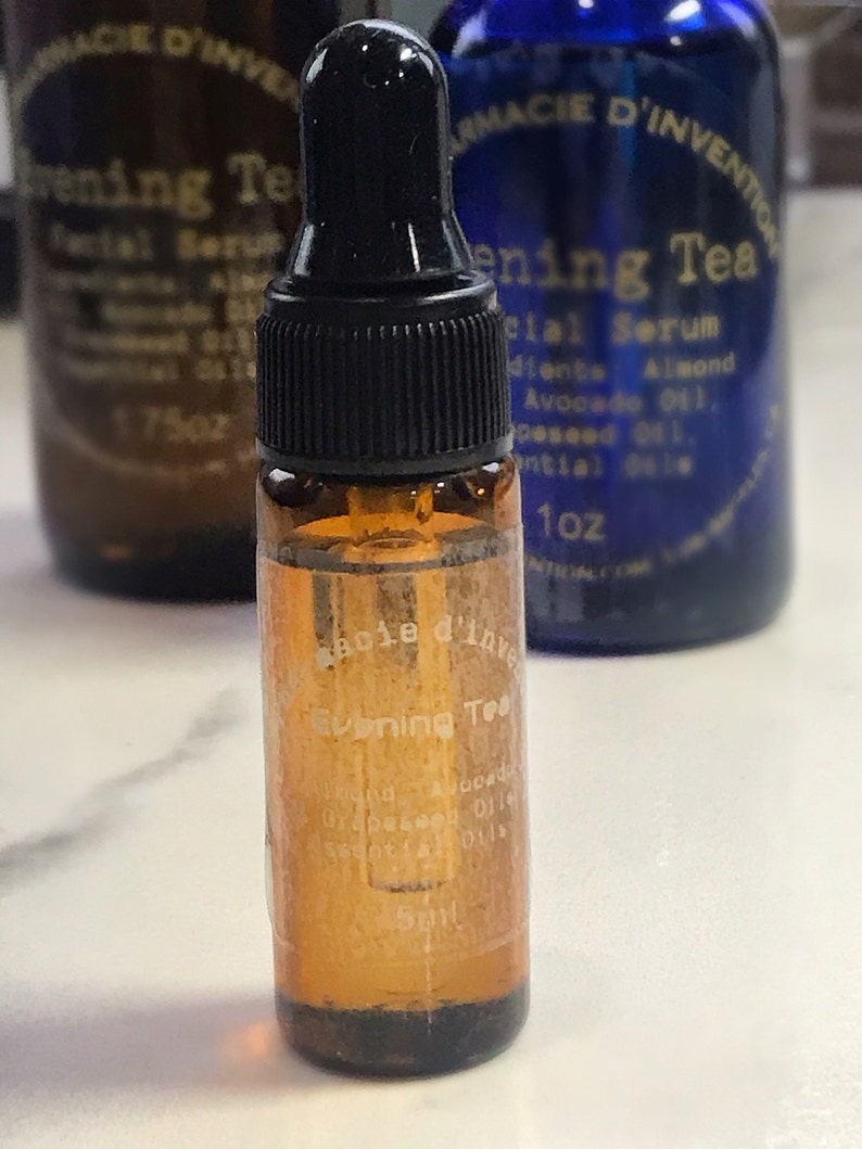 Puede incluir: Un peque&ntilde;o frasco de vidrio &aacute;mbar con un gotero negro. El frasco est&aacute; etiquetado como "Evening Tea" y contiene un suero facial. Los ingredientes incluyen almendras, aguacate y aceite de semilla de uva.