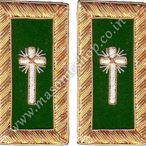 Puede incluir: Dos parches bordados rectangulares con fondo verde y diseño de cruz blanca. Los parches tienen un borde dorado ornamentado. El texto "www.mascshop.co.in" es visible en los parches.