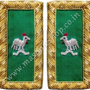 Puede incluir: Par de charreteras bordadas en verde y dorado. Cada charretera presenta un diseño de gallo corriendo en hilo plateado y rojo. Los bordes están adornados con trenza dorada, sobre un fondo de tela verde.