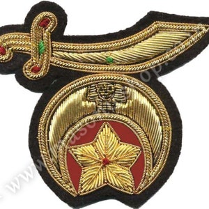 May include: A gold embroidered patch with a crescent moon, a five-pointed star, and a scimitar. The patch is on a black felt background.