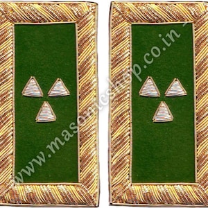 Puede incluir: Par de charreteras verdes y doradas. Cada charretera presenta un centro rectangular verde con tres emblemas triangulares bordados. Los bordes están adornados con detalles dorados intrincadamente tejidos. El sitio web www.masconicshop.co.in está impreso en la imagen.