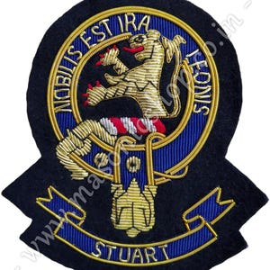 May include: A black felt embroidered patch with a gold lion rampant, a blue and gold ribbon with the text "STUART", and a gold circle with the text "NOBILIS EST IRA LEONIS".