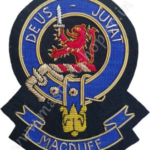 May include: A blue and gold embroidered crest with a red lion, a sword, and the text "DEUS JUVAT MACDUFF".