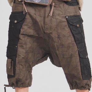May include: Brown and black patchwork shorts with multiple pockets. The shorts have a unique quilted pattern and a drawstring at the bottom. The shorts are made of a durable fabric.