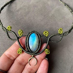 Può includere: Una collana in macramé verde scuro con un ciondolo in pietra preziosa blu e verde e un ciondolo a forma di mezzaluna.