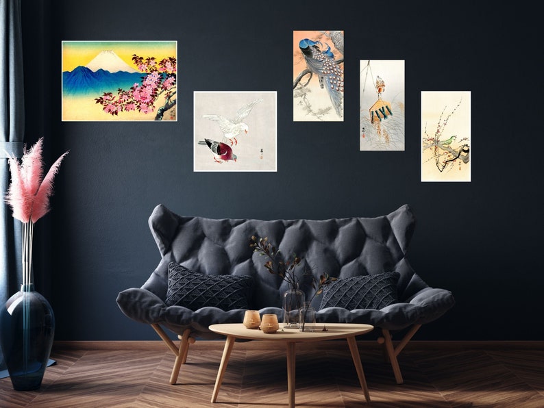 May include: A set of five Japanese-style art prints featuring a mountain scene, a peacock, a bird, a bird with a flower branch, and a bird with a flower branch. The prints are framed and hung on a dark blue wall.