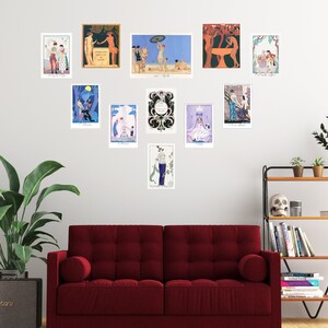 May include: A wall gallery featuring 12 framed art prints with various designs and colors. The prints are arranged in a symmetrical pattern on a white wall. The prints feature a variety of subjects, including people, animals, and abstract designs. The prints are all framed in simple, black frames.