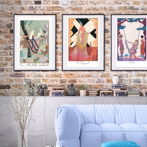 May include: Three framed art prints with black frames and white mats. The prints feature colorful illustrations of women in various poses. The first print features a woman in a pink dress with a black and white background. The second print features a woman in a blue dress with a green background. The third print features a woman in a red dress with a yellow background.