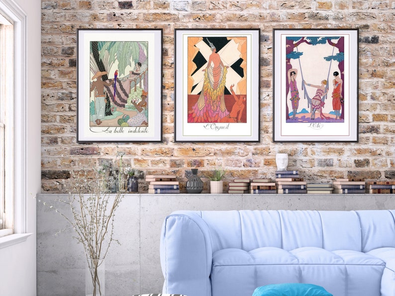 May include: Three framed art prints with black frames and white mats. The prints feature colorful illustrations of women in various poses. The first print features a woman in a pink dress with a black and white background. The second print features a woman in a blue dress with a green background. The third print features a woman in a red dress with a yellow background.