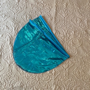 May include: A folded teal blue balloon with a metallic sheen.