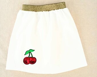 Falda blanca, 4/5 años, cintura elástica dorada, insignia cereza