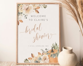 May include: A printable sign for a bridal shower with a watercolor floral design featuring pumpkins, leaves, and flowers in shades of orange, yellow, and green. The text reads "Welcome to Claire's Bridal Shower 11.27.20 Stateline, Nev."
