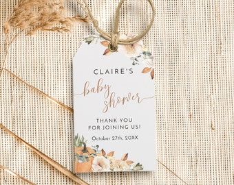 May include: A white tag with a floral design and the text "CLAIRE'S baby shower". The tag includes the text "THANK YOU FOR JOINING US!" and "October 27th, 20XX". A twine loop is attached to the tag.