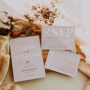 May include: A wedding stationery set in pale pink, including an invitation, RSVP card, and details card. The invitation features the names Claire and William, the date, and venue details. The design is elegant.