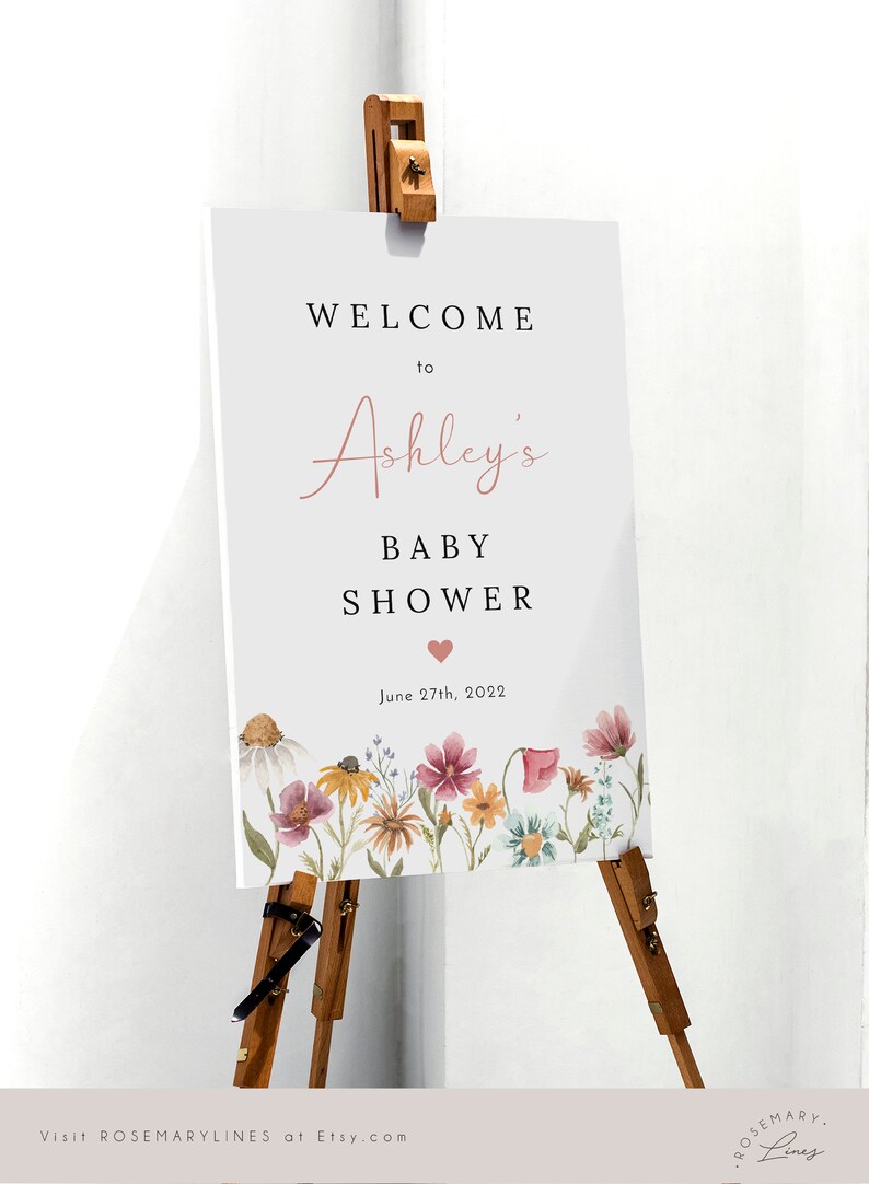 May include: Welcome to Ashley's Baby Shower sign with a floral border and the date June 27th, 2022.