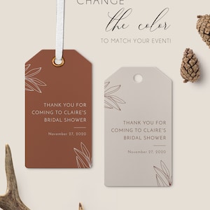 May include: Two gift tags with a floral design and the text "Thank you for coming to Claire's Bridal Shower" are displayed. One tag is brown, the other is beige. The tags have a white ribbon and the text "Change the color to match your event!"