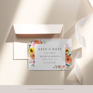 May include: Save the date card with a watercolour floral border in shades of pink, orange, yellow, and green. The text reads "Save the Date for the wedding of Kathy & Joshua April 27th, 2021. Formal invitation to follow."