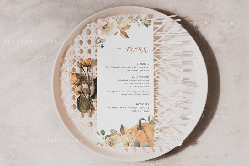 K&ouml;nnte beinhalten: Eine Men&uuml;karte mit floralen und K&uuml;rbis-Illustrationen, pr&auml;sentiert auf einem wei&szlig;en Teller mit einem dekorativen Webmuster. Das Men&uuml; zeigt einen handgeschriebenen Titel "Men&uuml;" und eine Liste von Gerichten.