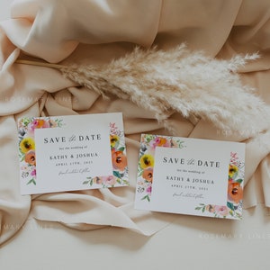 May include: Two save the date cards with floral borders. The cards are white with black text. The text reads "Save the Date" for the wedding of Kathy & Joshua, April 27th, 2021. The floral borders are watercolour style with pink, yellow, orange, and green flowers.