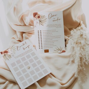 May include: Two wedding game cards with floral and botanical designs. One card is titled "Over or Under" with a list of questions. The other card is "Bridal Bingo". Both cards have a neutral color palette.