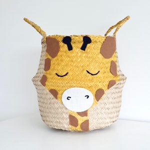 Giraffe seagrass belly basket with a hand painted and embroidered face. In a yellow mustard colour storage bin