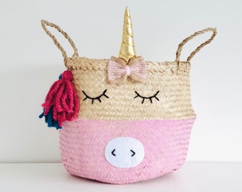 Large unicorn seagrass belly basket with hand embroidered eyelashes hand painted in baby pink with rainbow tassels by Bellybambino