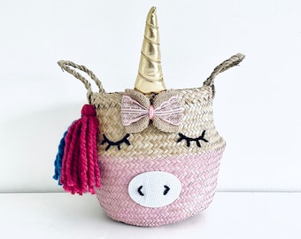 Small unicorn seagrass belly basket with hand embroidered eyelashes hand painted in baby pink with rainbow tassels by Bellybambino