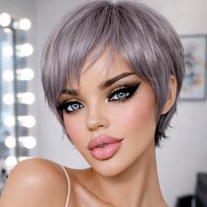 Könnte beinhalten: Eine Person mit heller Haut und blauen Augen, die ein helles Spaghettiträger-Top trägt. Sie hat kurze, graue Haare und volle Lippen. Das Bild enthält den Text "ELESSA" in einem geometrischen Design.