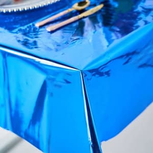 Op de afbeelding: Close-up van een glanzend blauw tafelkleed met een reflecterend oppervlak.