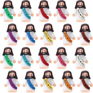 May include: A group of small Jesus figurines, each with a dark beard and hair, and wearing white robes. They have colourful sashes with the text "Jesus ❤️ You". The sashes are in various colours, including green, blue, red, yellow, orange, purple, and white.