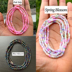 Pu&ograve; includere: Tre collane di perline. Una &egrave; rosa con piccoli accenti dorati etichettata Pink Tulip. Una &egrave; multicolore pastello con perline bianche, rosa, blu e verdi etichettata Spring Blossom. Una &egrave; blu iridescente scuro con finitura metallica etichettata Blue iridescent.