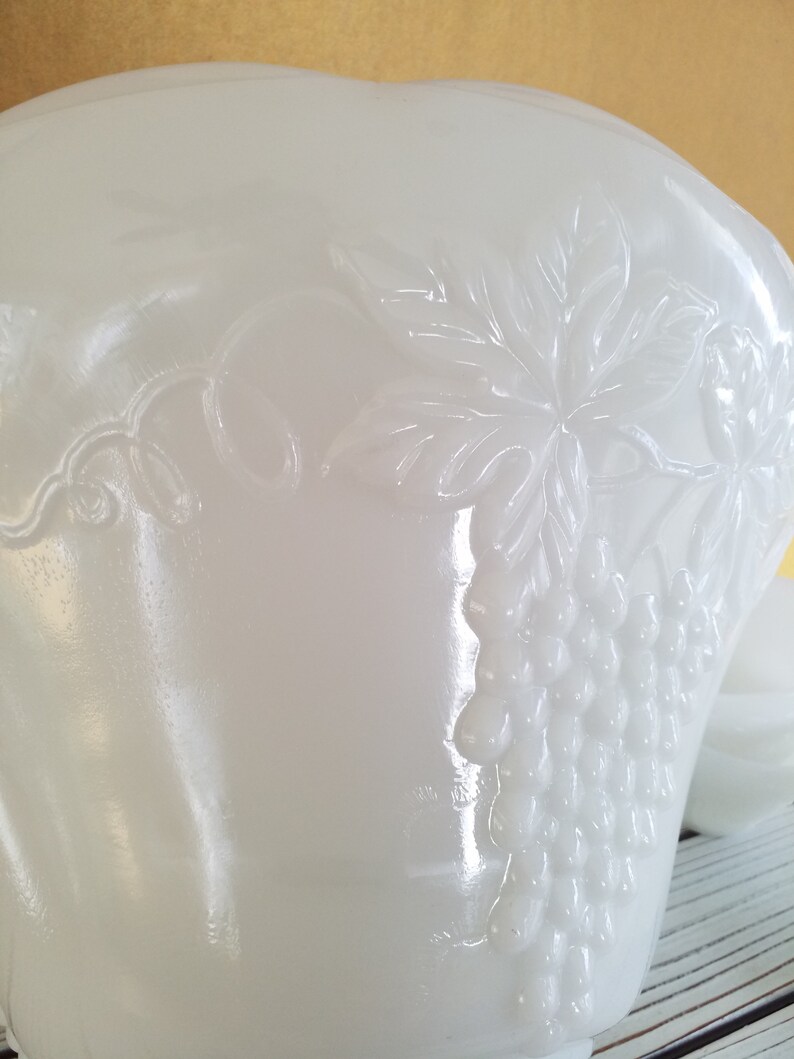 May include: White milk glass bowl with an embossed grapevine design. The bowl has a scalloped edge and is perfect for serving salads, fruit, or desserts.