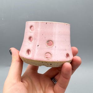 Peut inclure: Ensemble de trois tasses en céramique avec une finition mate et mouchetée. Les tasses sont de couleur crème, marron clair et marron foncé. Chaque tasse a un design simple et minimaliste avec une anse arrondie.