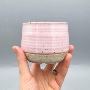 以下が含まれることがあります： つや消し仕上げの、斑点模様のセラミックマグカップ3個セット。マグカップはクリーム色、ライトグレー、ダークグレーの色合いです。各マグカップはシンプルでミニマルなデザインで、丸みを帯びたハンドルが付いています。マグカップは積み重ねられています。