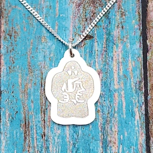 May include: A silver necklace featuring a pendant shaped like a yeti. The pendant has a detailed design of a yeti with a small anchor on its chest.