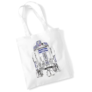 May include: White tote bag with a detailed black and white illustration of R2-D2, the Star Wars droid, with blue accents. The bag has two white handles, perfect for carrying items.