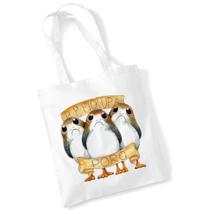 May include: White tote bag featuring a graphic of three Porg characters from Star Wars. The Porg characters are holding a banner that reads "P-P-Pickupa Porg".