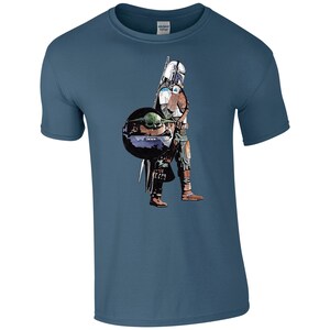 K&ouml;nnte beinhalten: Ein blaues T-Shirt mit einem Grafikdruck eines Mandalorianer-Charakters, der ein kleines gr&uuml;nes Alien, bekannt als "The Child" oder "Baby Yoda", in einer schwebenden Kapsel tr&auml;gt.