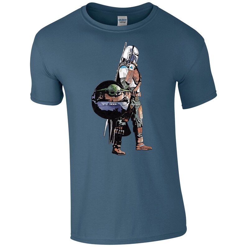K&ouml;nnte beinhalten: Ein blaues T-Shirt mit einem Grafikdruck eines Mandalorianer-Charakters, der ein kleines gr&uuml;nes Alien, bekannt als "The Child" oder "Baby Yoda", in einer schwebenden Kapsel tr&auml;gt.