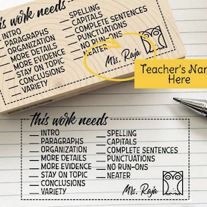 May include: A wooden stamp with the text "This work needs" and a list of writing and presentation skills. The stamp also includes an owl illustration and the text "Mrs. Raja".