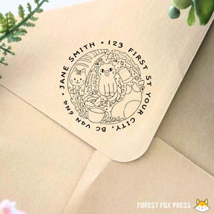 May include: A round, black and white return address stamp with a cat, a coffee cup, and flowers. The text reads "CITY, YOUR ST 123 FIRST JANE SMITH, BC V4N 6N4".