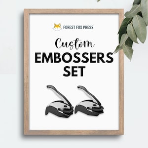 May include: A white framed poster with the text "FOREST FOX PRESS" and "Custom Embossers Set" in black. Two black and silver embossers are shown below the text.