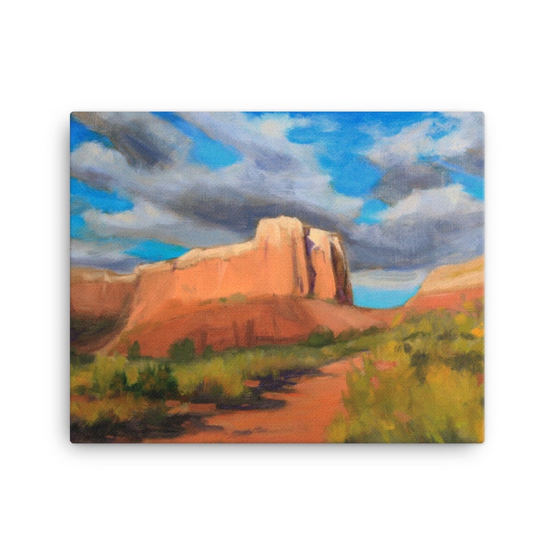 May include: A painting of a red rock formation in a desert landscape. The sky is blue with white clouds. The rock formation is tall and narrow, with a flat top. There is a path leading up to the rock formation.
