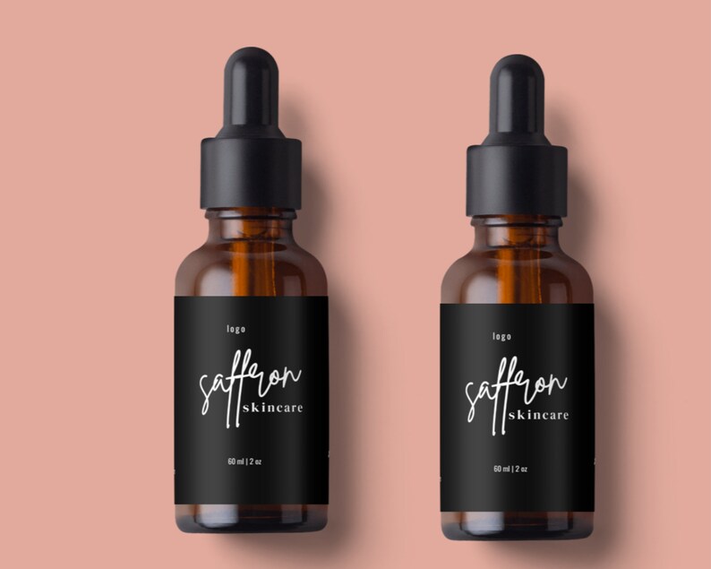 May include: Two amber glass dropper bottles with black caps and labels that read "saffron skincare". Each bottle contains 2 fl oz (60 ml) of product. The bottles are set against a peach-colored background.