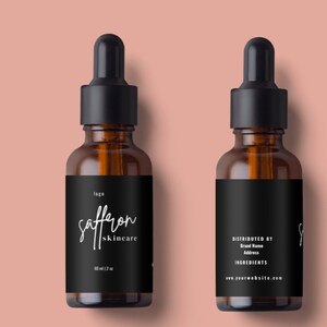 May include: Two amber glass dropper bottles with black caps and labels. The front label reads "saffron skincare" in white script. The bottles are 2 oz. The back label includes "Distributed by", "Brand Name", "Address", "Ingredients", and a website address.
