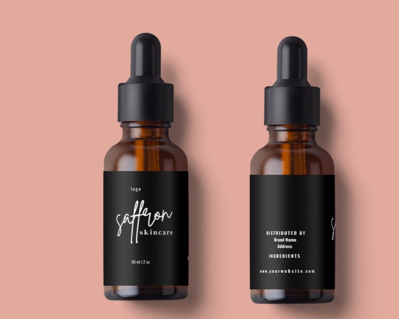 May include: Two amber glass dropper bottles with black caps and labels. The front label reads "saffron skincare" in white script. The bottles are 2 oz. The back label includes "Distributed by", "Brand Name", "Address", "Ingredients", and a website address.